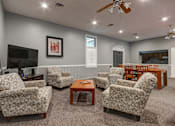Thumbnail 13 of 26 - A living room with a grey wall and a ceiling fan.