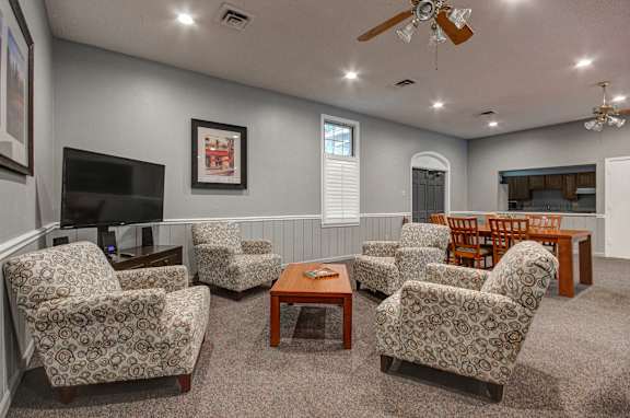 A living room with a grey wall and a ceiling fan.