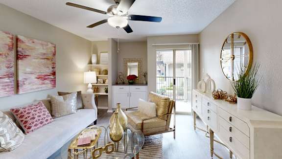 A living room with a white couch, a coffee table, and a ceiling fan.