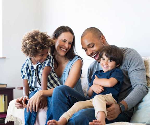 a family sitting on a couch with their children at Buzza Lofts of Uptown, MN 55408