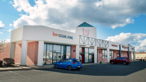 the exterior of a store with two cars parked in front of it