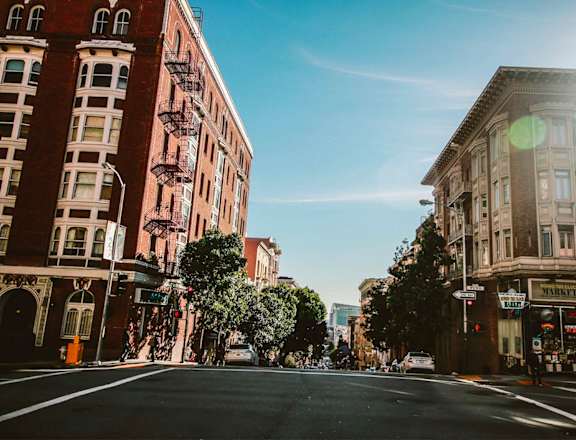 a city street with buildings on a sunny day