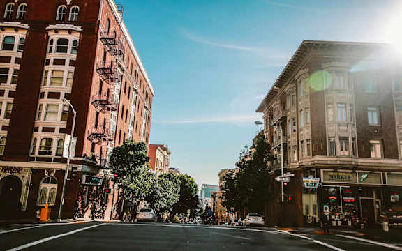 a city street with buildings on a sunny day