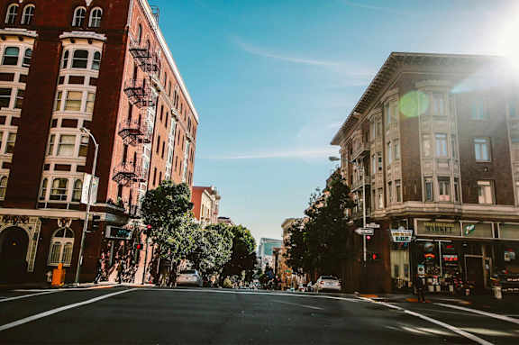 a city street with buildings on a sunny day