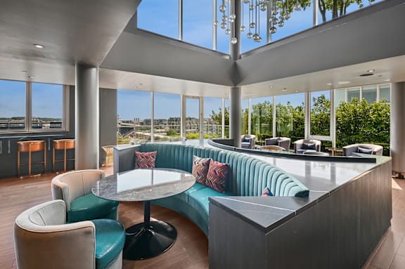 A modern lounge area with a curved sofa and a round table.