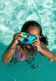 A person is taking a photo underwater with a blue camera.