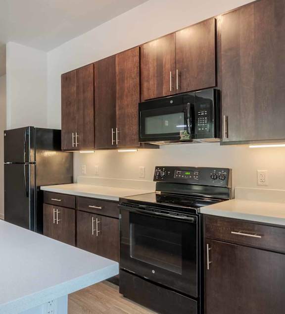 a kitchen with a bar and stools and a living room with a couch at Pinnex, Indianapolis, IN, 46203