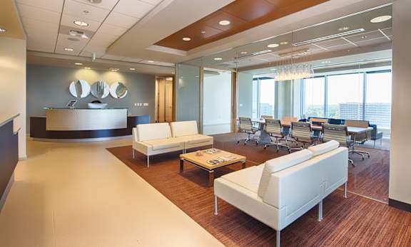 A modern office space with white furniture and wood flooring.