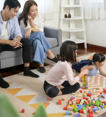 a family sitting in a living room playing with blocks