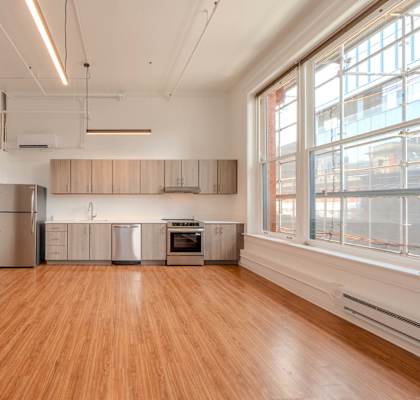 A kitchen with wooden floors and stainless steel appliances.