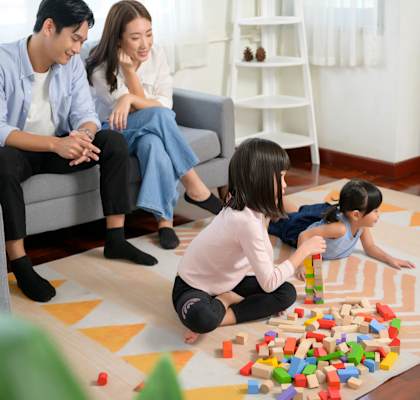 a family sitting in a living room playing with blocks