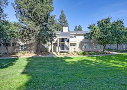 the front of a house with a yard and trees
