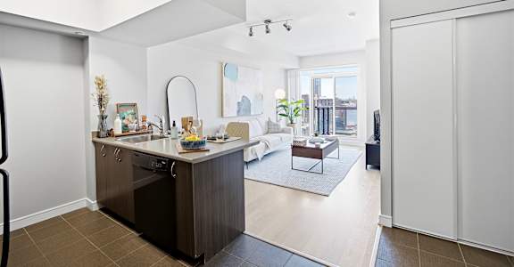 A modern kitchen with a large island and a view of the city.