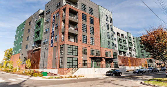 A large multi-story building with a green and brown exterior at Harbor Side at Conwood Flats Apartments, Memphis