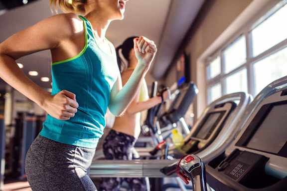 a woman running on a treadmill in a gym at Paramount on Lake Eola, Orlando, FL, 32801