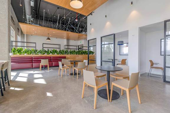 A modern dining area with wooden chairs and tables. at Riverfront Everett, Washington, 98201