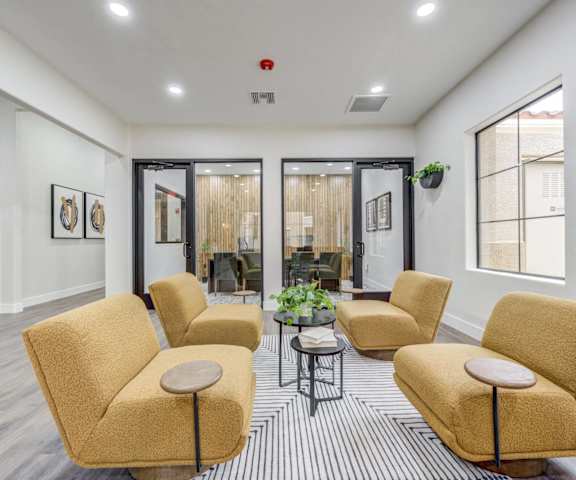 The resident lounge with couches, plush chairs, and coffee tables at Desert Club. 