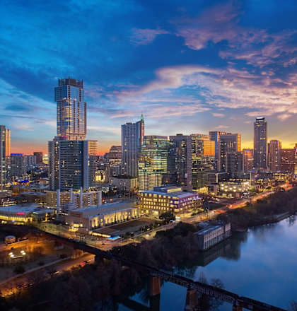 A cityscape at dusk with a river running through it.