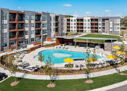 A large swimming pool surrounded by a grassy area and trees.