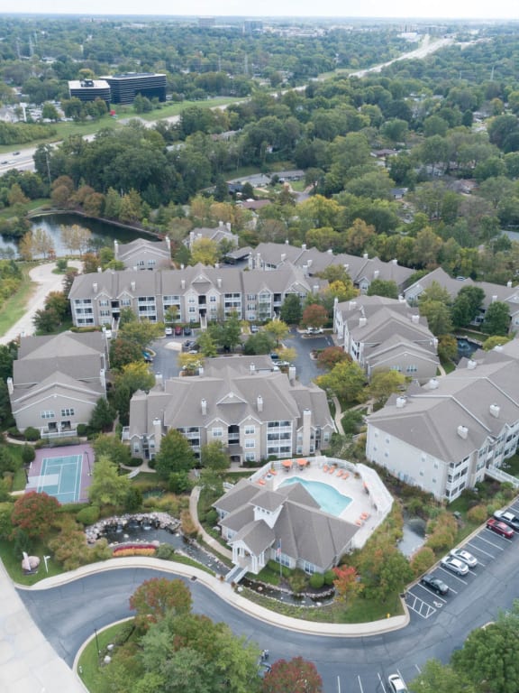 an aerial view of a large complex of houses with trees in the background