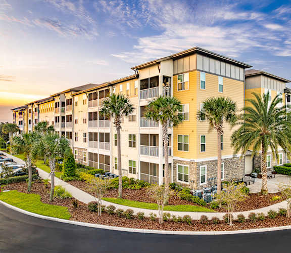 A large apartment complex with a parking lot in front.