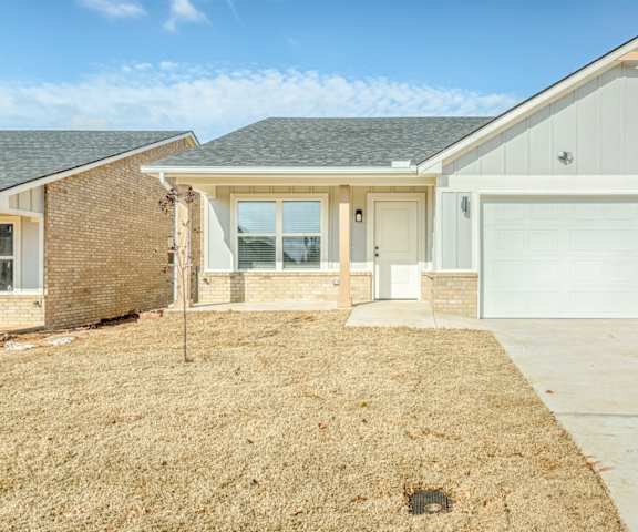 A house with a garage and a driveway in front.