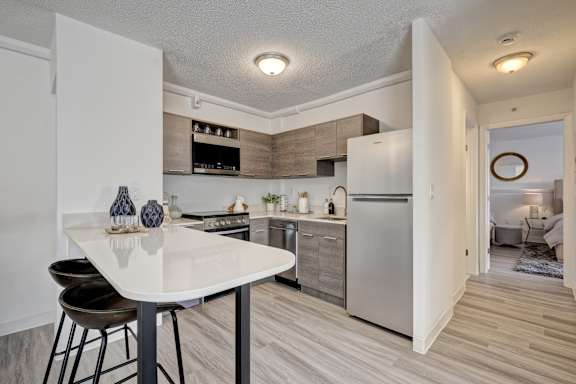 A modern kitchen with a stainless steel refrigerator, oven, and microwave.