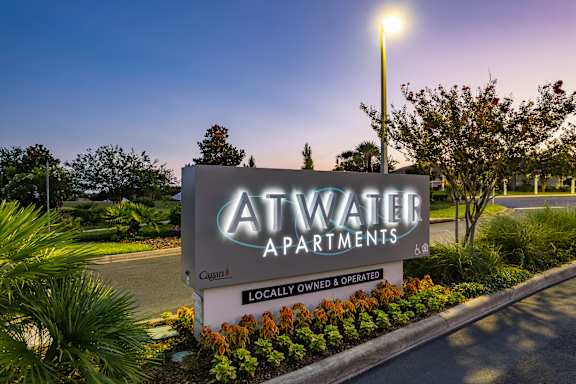 A sign for Atwater Apartments is displayed in front of a well-landscaped area.