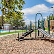 A playground with a blue slide and wooden structure.