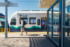 a man walking on a platform in front of a white and blue train