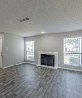 A living room with a fireplace and wood flooring.