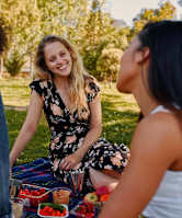 Three women having a picnic in a park.