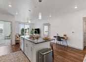 Thumbnail 10 of 20 - an open kitchen and living room with a large island and a dining room