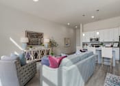 Thumbnail 9 of 21 - Living room with a grey couch and a white couch with a pink pillow on it at 200 City View, Provo, 84601