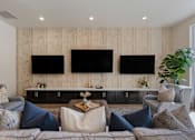 Thumbnail 27 of 49 - Living room with couches and chairs and televisions on the wall at 200 City View, Provo