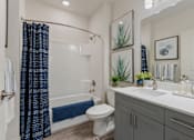 Thumbnail 15 of 21 - Bathroom with a white toilet, a white sink, a blue shower curtain, and a white bathtub at 200 City View, Provo, UT, 84601