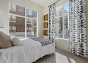 Thumbnail 18 of 21 - Bedroom with a large bed and a window with a patterned curtain at 200 City View, Provo, 84601