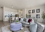 Thumbnail 10 of 21 - Modern living room with a grey couch and a round ottoman at 200 City View, Provo, Utah