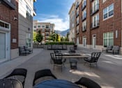 Thumbnail 33 of 49 - Outdoor patio with tables and chairs and a fire pit at 200 City View, Provo