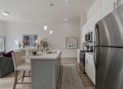 Thumbnail 2 of 21 - Modern kitchen with a stainless steel refrigerator and a dining table with chairs at 200 City View, Provo, 84601