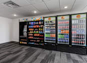 Thumbnail 30 of 42 - Self-service snack station with a 'Pay Here' kiosk, chips, and assorted bottled sodas and water. 605 Place Student Housing & Co-Living, St George, 84770