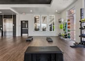 Thumbnail 26 of 42 - A gym with a wooden floor and a variety of equipment 605 Place Student Housing & Co-Living, St George, UT 84770.