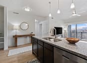 Thumbnail 3 of 26 - A modern kitchen with a large island and a view of the mountains.