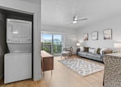 Thumbnail 15 of 26 - A modern living room with a television and a balcony overlooking the city.
