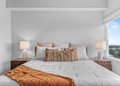 Thumbnail 17 of 26 - A bed with a white comforter and a brown throw blanket is in the center of the image.