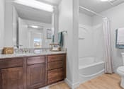 Thumbnail 20 of 26 - A bathroom with a white toilet, a white sink, and a white bathtub.