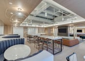 Thumbnail 3 of 19 - A modern open space with a bar and seating area.