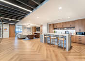 Thumbnail 2 of 19 - A modern kitchen with wooden floors and a bar area.