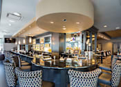 Thumbnail 9 of 18 - A restaurant with a bar and chairs.