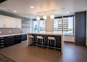 Thumbnail 5 of 18 - A modern kitchen with a bar stool and a view of the city.